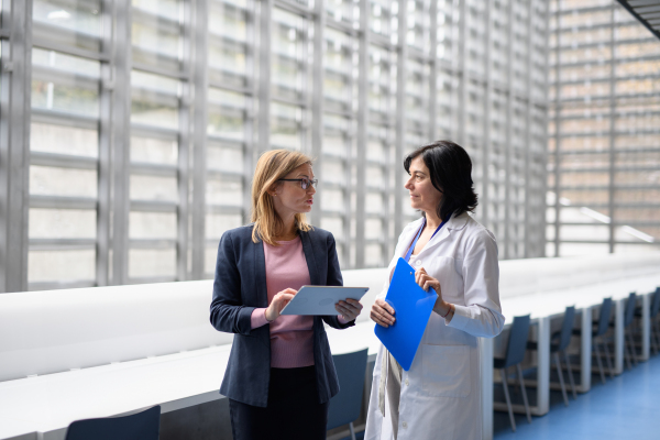 Doctor talking to pharmaceutical sales representative, presenting new pharmaceutical product. Hospital director, manager talking with doctors team.