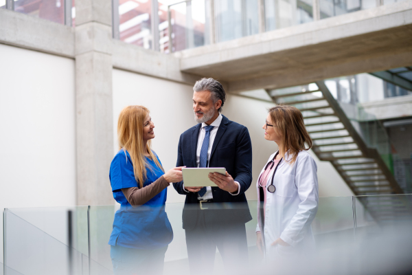 Doctors talking to pharmaceutical sales representative, presenting new pharmaceutical product. Hospital director, manager talking with doctors team.