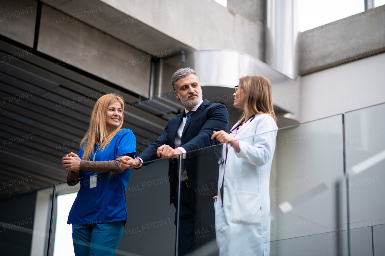 Doctors talking to pharmaceutical sales representative, presenting new pharmaceutical product. Hospital director, manager talking with doctors team.