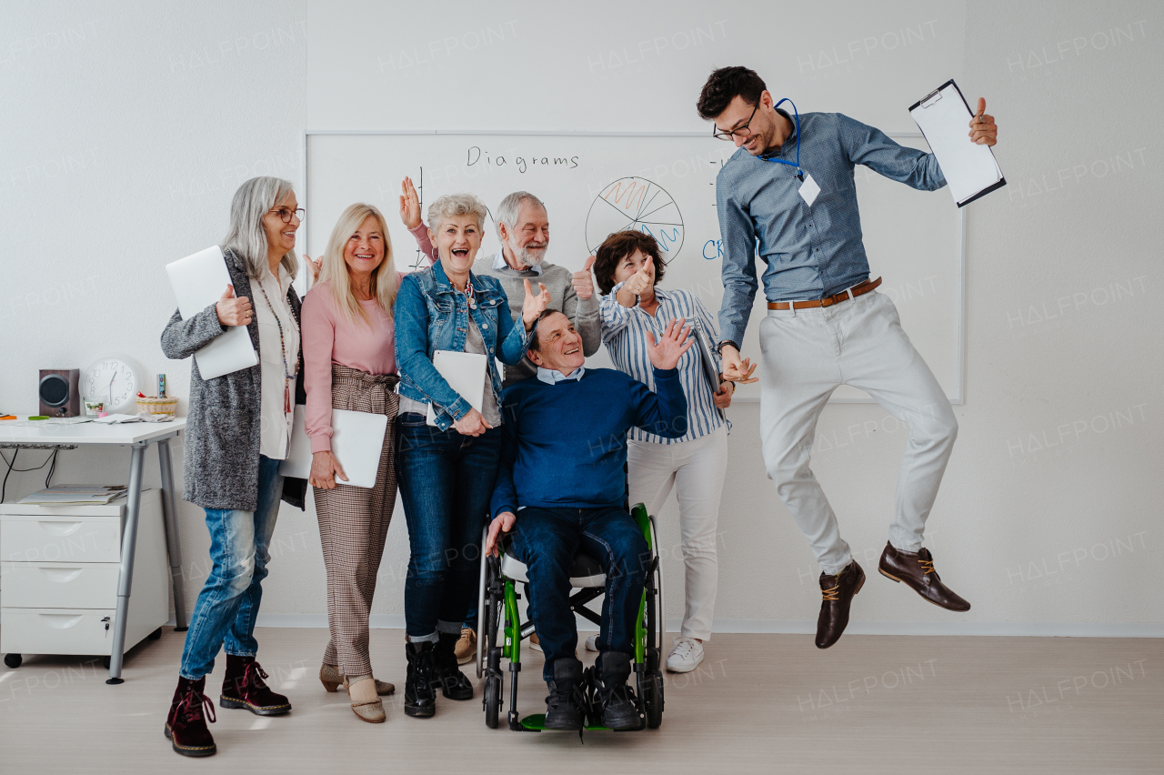 Portrait of young teacher and senior students. Elderly people attending computer and technology education class. Digital literacy.