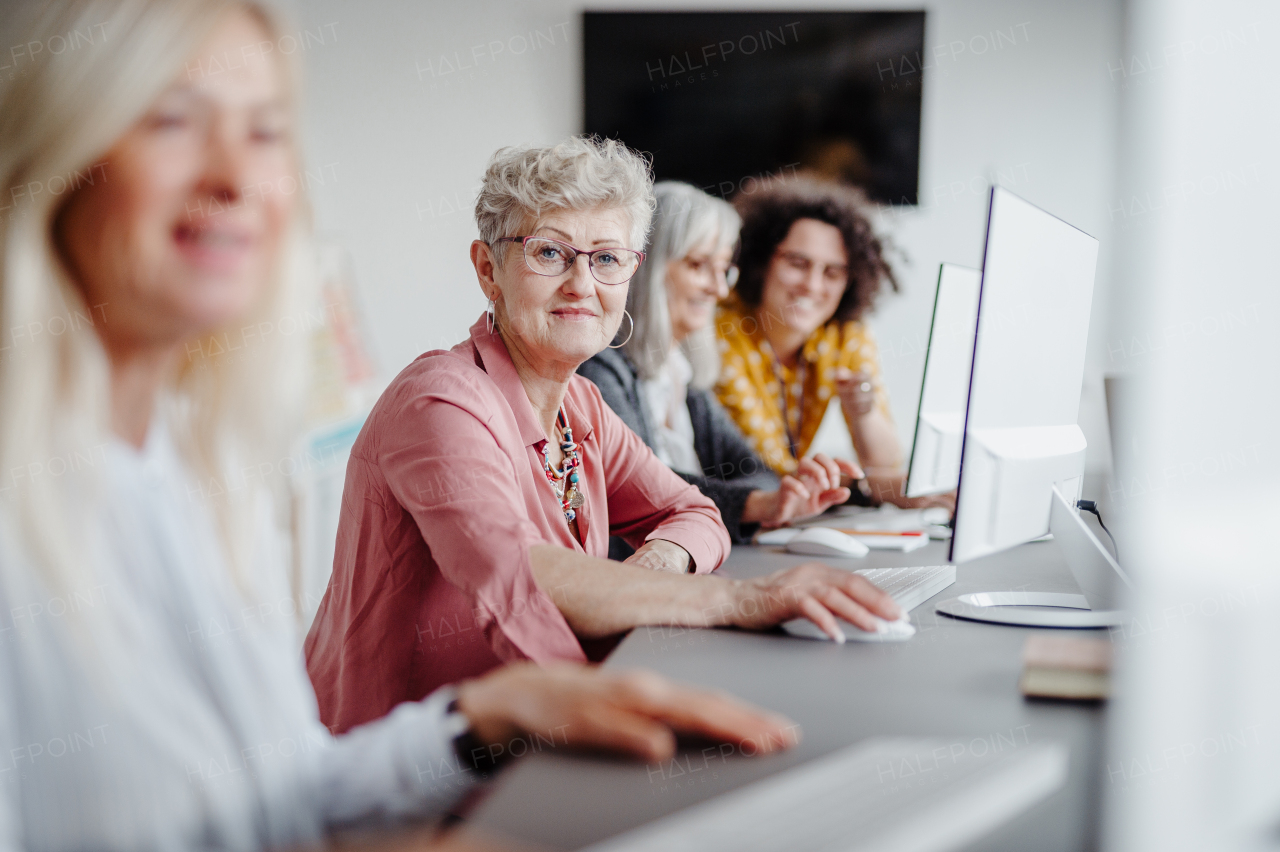 Portrait of female senior students learning how to work with digital technology. Elderly people attending computer and technology education class.