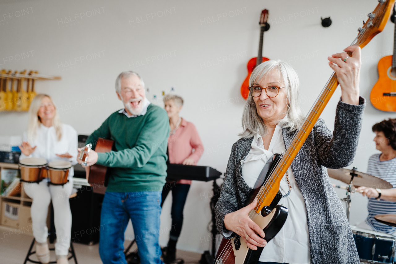 Group of seniors meeting to play musical instruments together in band. Therapeutic effect of music for elderly people.