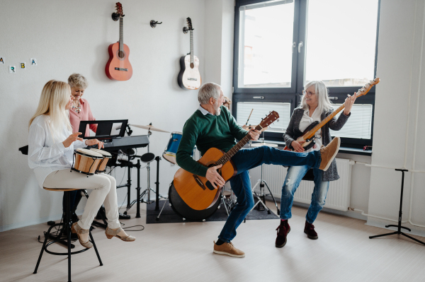 Group of seniors meeting to play musical instruments together in band. Therapeutic effect of music for elderly people.