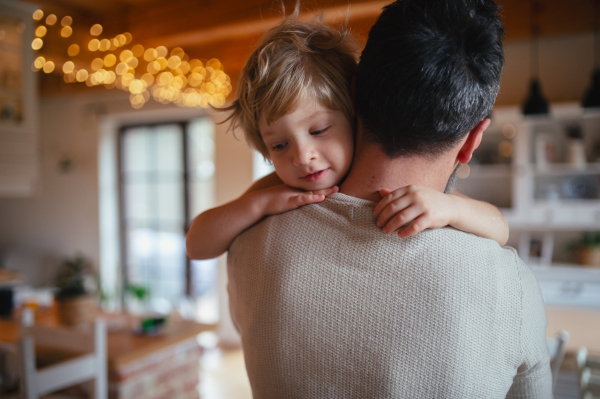 Father is holding his little son in his arms, hugging him. Fatherhood and Father's Day concept.