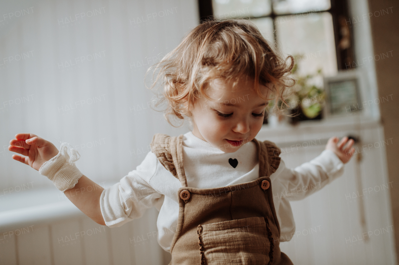 Portrait of an adorable little girl sitting on stool in bathroom