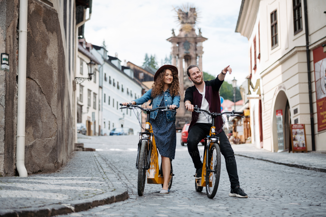 Couple travellers on electric scooters in city, sightseeing. Young tourist using bikes during their summer trip, vacation.