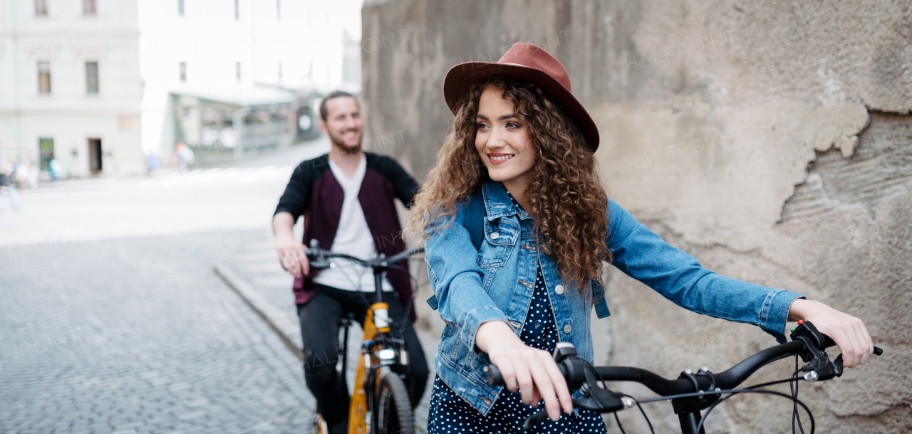 Couple travellers on electric scooters in city, sightseeing. Young tourist using bikes during their summer trip, vacation. Banner with copyspace.