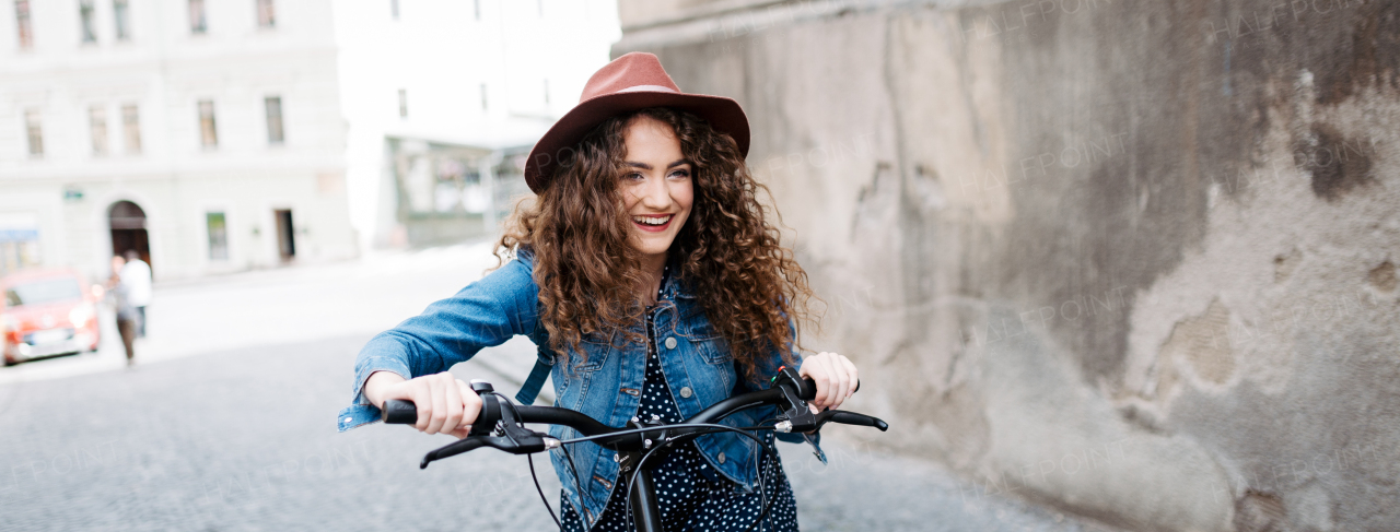 Female traveller on electric scooter in small city, sightseeing. Beautiful tourist using bike during her summer solo trip, vacation. Banner with copyspace.