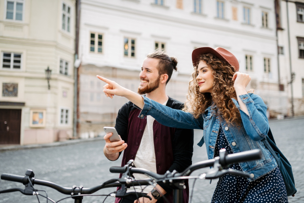 Couple travellers on electric scooters in city, sightseeing. Young tourist using bikes during their summer trip, vacation.