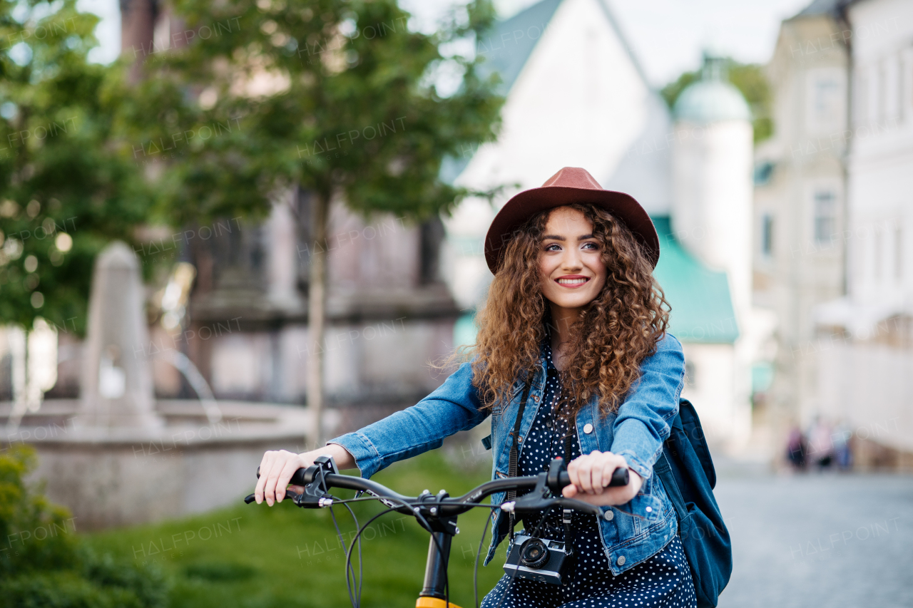 Female traveller on electric scooter in small city, sightseeing. Beautiful tourist using bike during her summer solo trip, vacation.