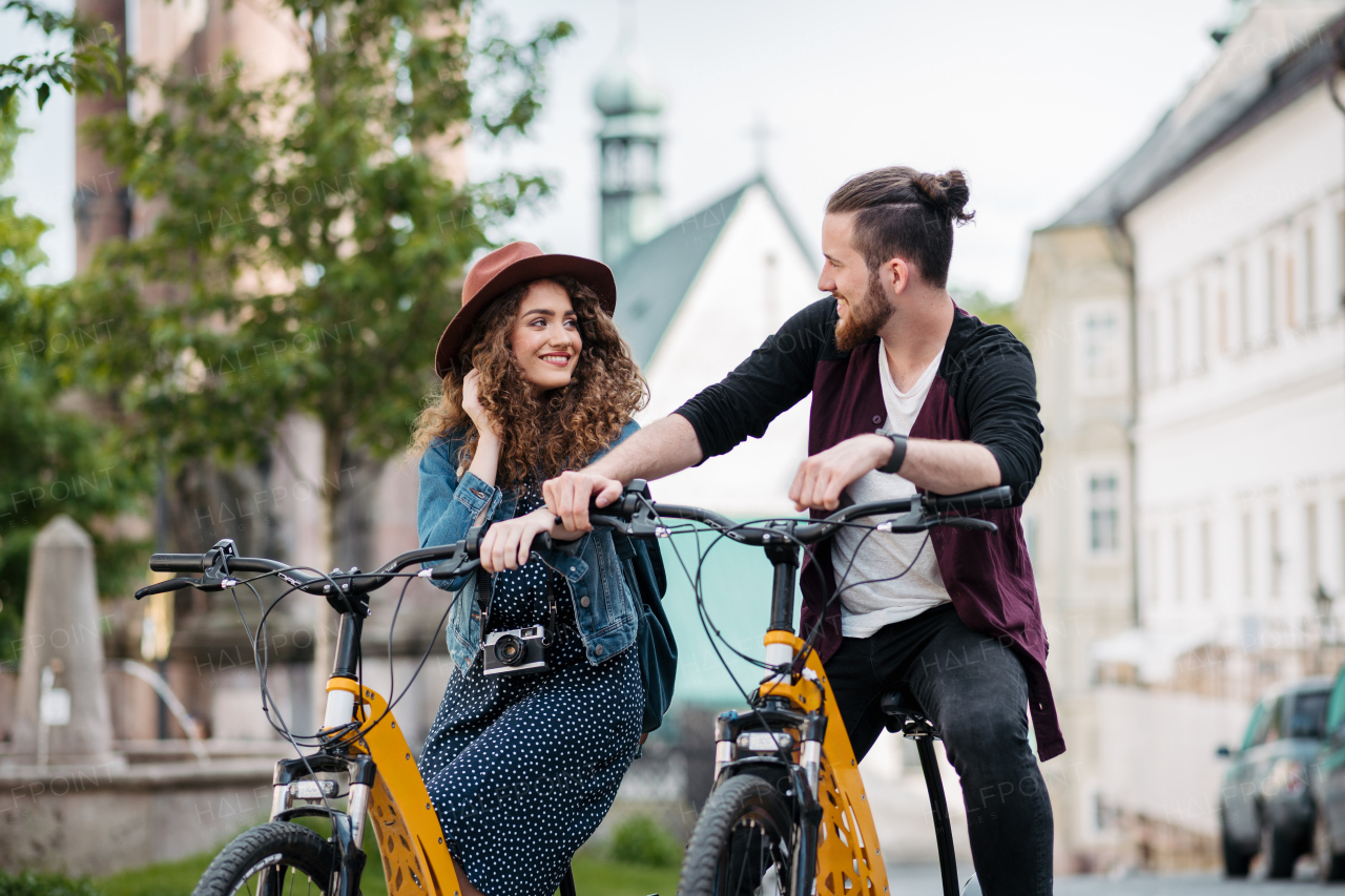 Couple travellers on electric scooters in city, sightseeing. Young tourist using bikes during their summer trip, vacation.