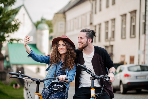 Couple travellers on electric scooters in city, sightseeing. Young tourist using bikes during their summer trip, vacation.