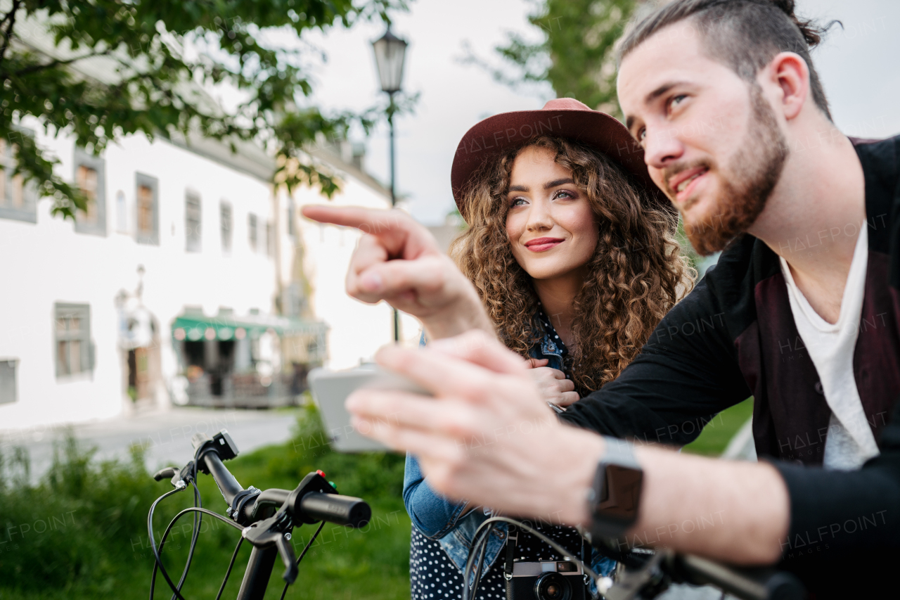 Couple travellers on electric scooters in city, sightseeing. Young tourist using bikes during their summer trip, vacation.