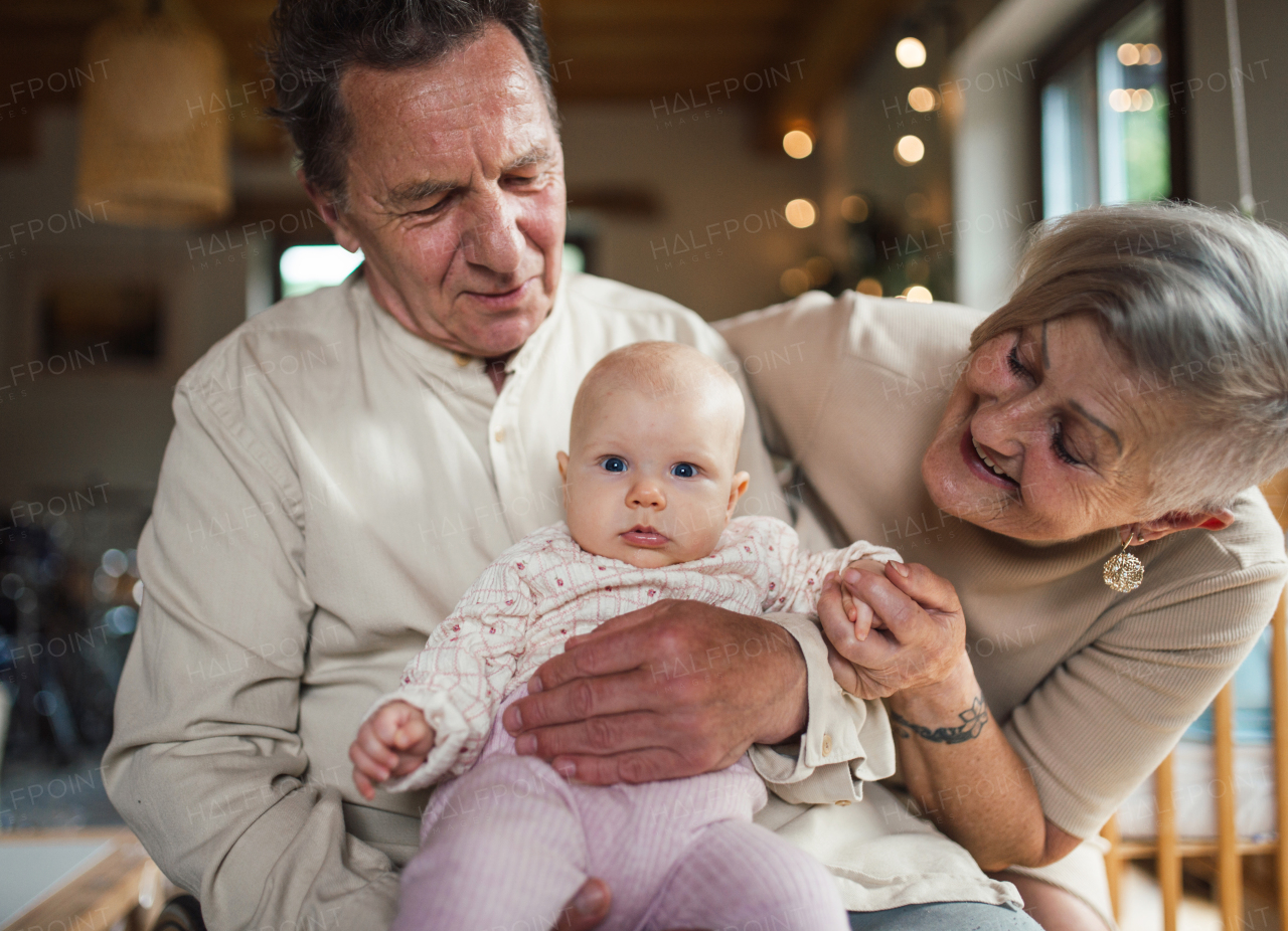 Grandparents holding small baby girl, calming her down, soothing her. Strong bond between grandparents and their grandchild.