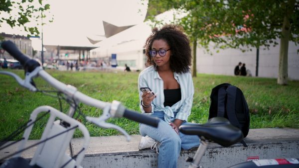 A beautiful university student is commuting through the city by bike, heading to class.