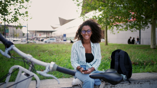 A beautiful university student is commuting through the city by bike, heading to class.