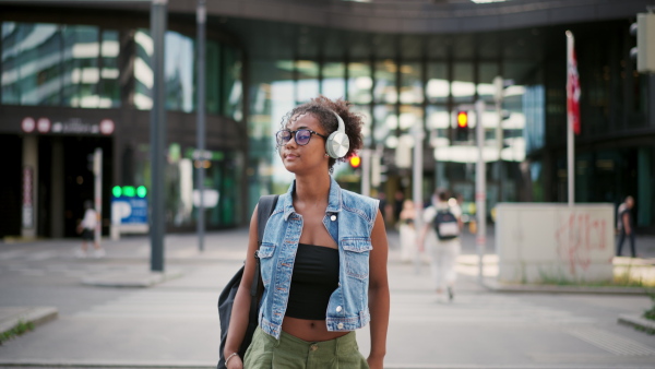 A video of gorgeous young woman with eyeglasses in the city, headphones on head.