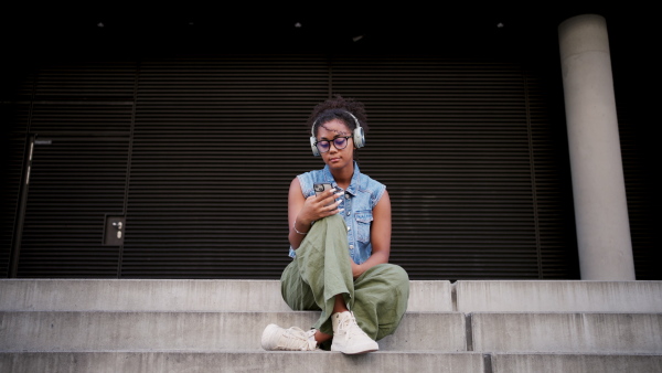 A video of gorgeous young woman with eyeglasses in the city, headphones on head.