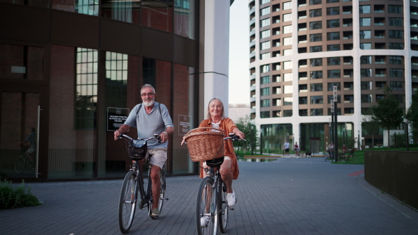 A senior couple enjoying hot summer in the city, going on bike ride around the city. Staycation concept.