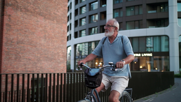 A senior man enjoying hot summer in the city, going on bike ride around the city. Staycation concept.