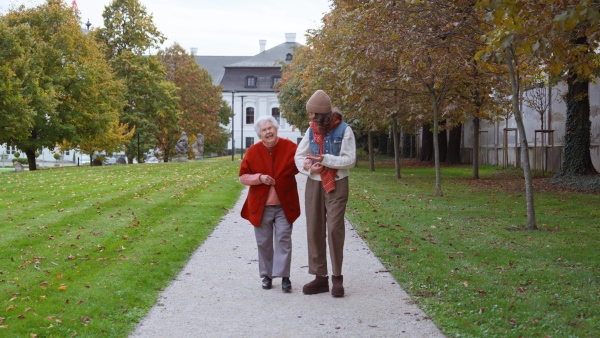 A video of granddaughter on an autumn walk in the park with her grandmother.