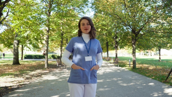 A video of beautiful nurse withhair in face, standing outdoors.