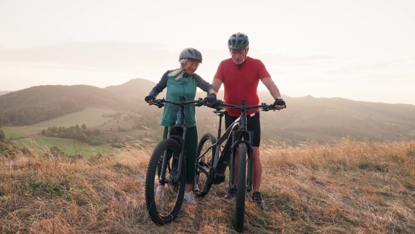 A video of beautiful senior couple on bike ride in autumn nature.