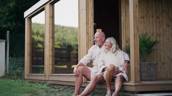 A husband and wife relaxing after spa session in home sauna. Concept of hygge and slow life for senior people.