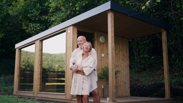 A husband and wife relaxing after spa session in home sauna. Concept of hygge and slow life for senior people.