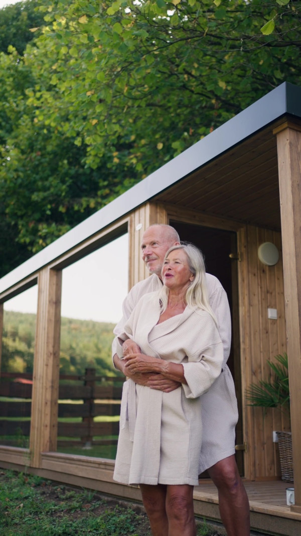 A husband and wife relaxing after spa session in home sauna. Concept of hygge and slow life for senior people.