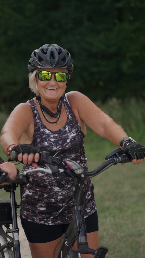 A video of beautiful senior cyclist on bike tour in nature. Older woman on low impact route riding electric bikes.