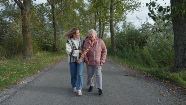 Autumn walk, a senior woman and her daughter spending a chilly, windy day outdoors in nature.