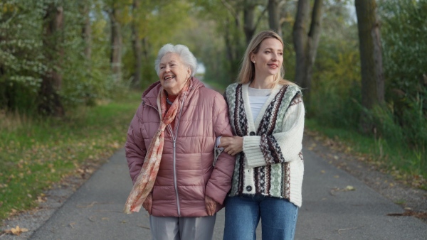 Autumn walk, a senior woman and her daughter spending a chilly, windy day outdoors in nature.