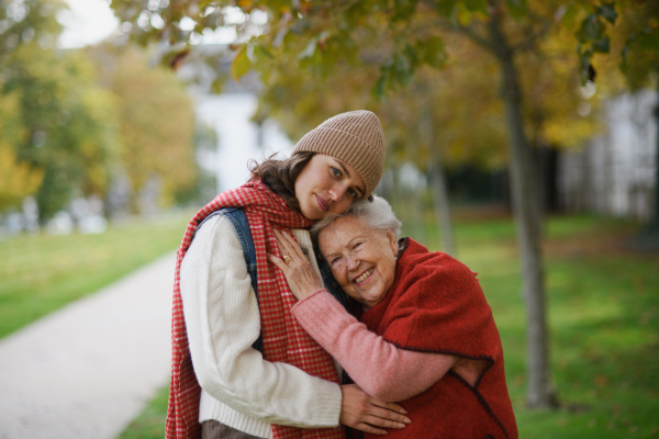 Portrait of granddaughter on an autumn walk in the park with her grandmother.