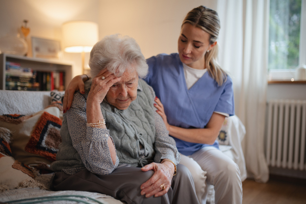 Nurse hugging elderly patient, mental health support and grief counseling to a senior woman.