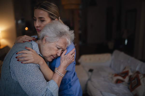 Nurse hugging elderly patient, mental health support and grief counseling to a senior woman.