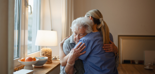 Psychologist, caregiver provides mental health support and grief counseling to female elderly patient. Banner with copy space.