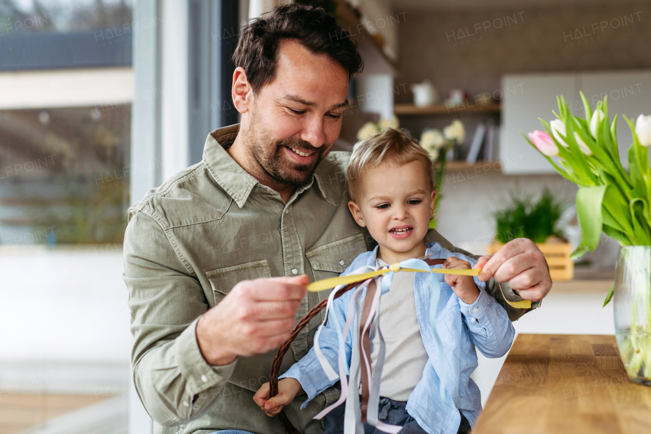 Father and little boy braiding easter whip from willow branches.