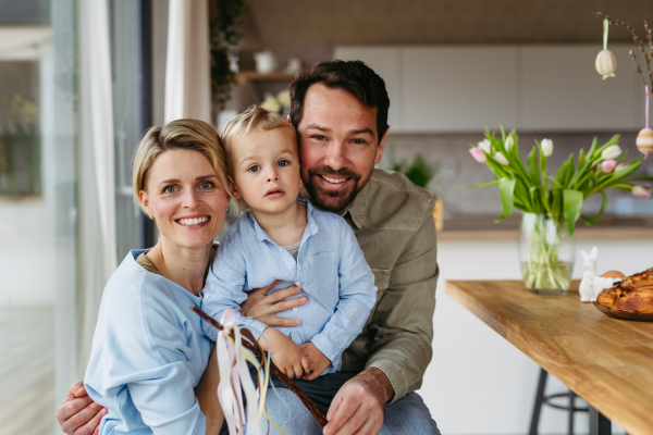 Family portrait with little boy holding easter whip from willow branches, decorated with ribbons.