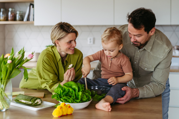 Family preparing lettuce salad to celebrate Easter Green Thursday. Green dish during Maundy thursday.