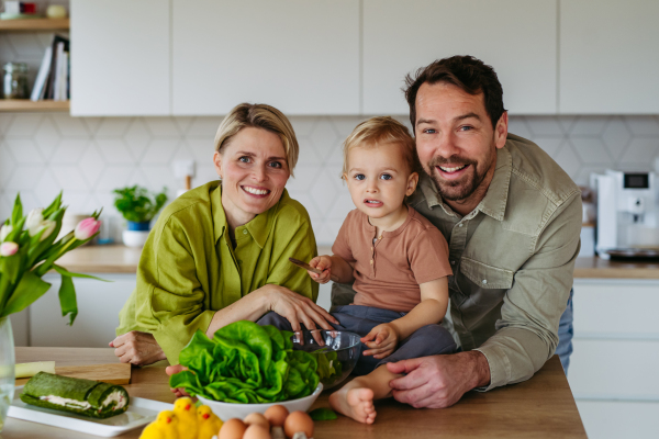 Family preparing lettuce salad to celebrate Easter Green Thursday. Green dish during Maundy thursday.