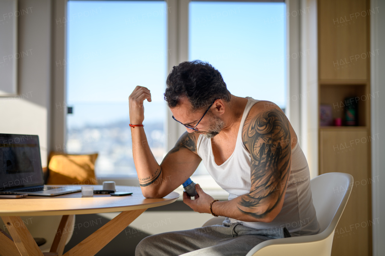 Diabetic man using sensor applicator to insert the CGM sensor into his arm.