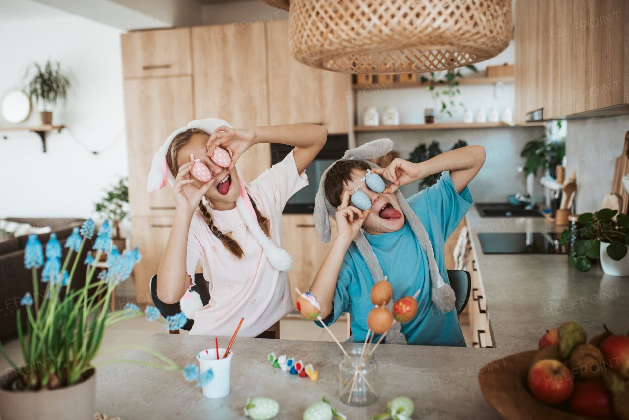 Siblings holding decorated easter eggs in front their eyes. Paiting eggs for easter.