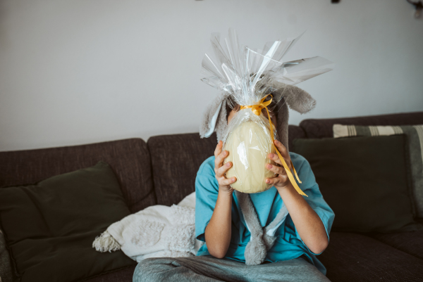 Boy with large Easter egg in front his face. Easter celebration.