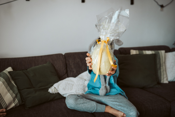 Boy holding huge Easter egg in front him. Easter celebration.