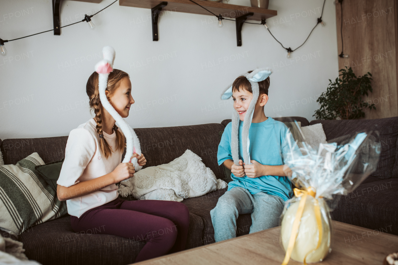 Little girl gifting a large Easter egg to young boy.