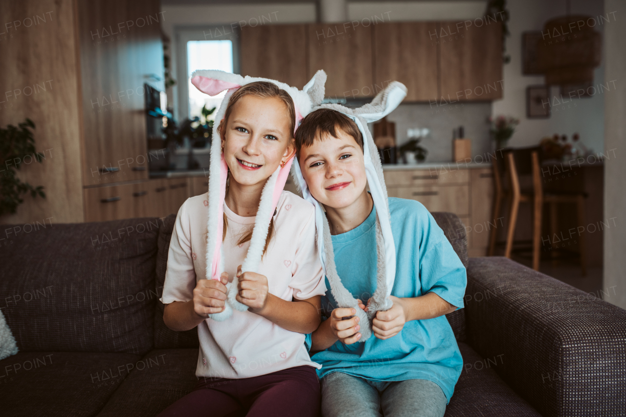 Brother and sister wearing bunny ear headbands. Siblings celebrating Easter.