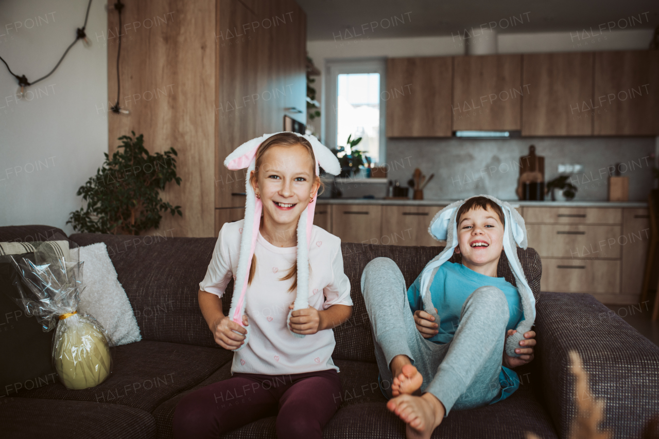 Brother and sister wearing bunny ear headbands. Siblings celebrating Easter.