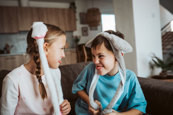 Brother and sister wearing bunny ear headbands. Siblings celebrating Easter.