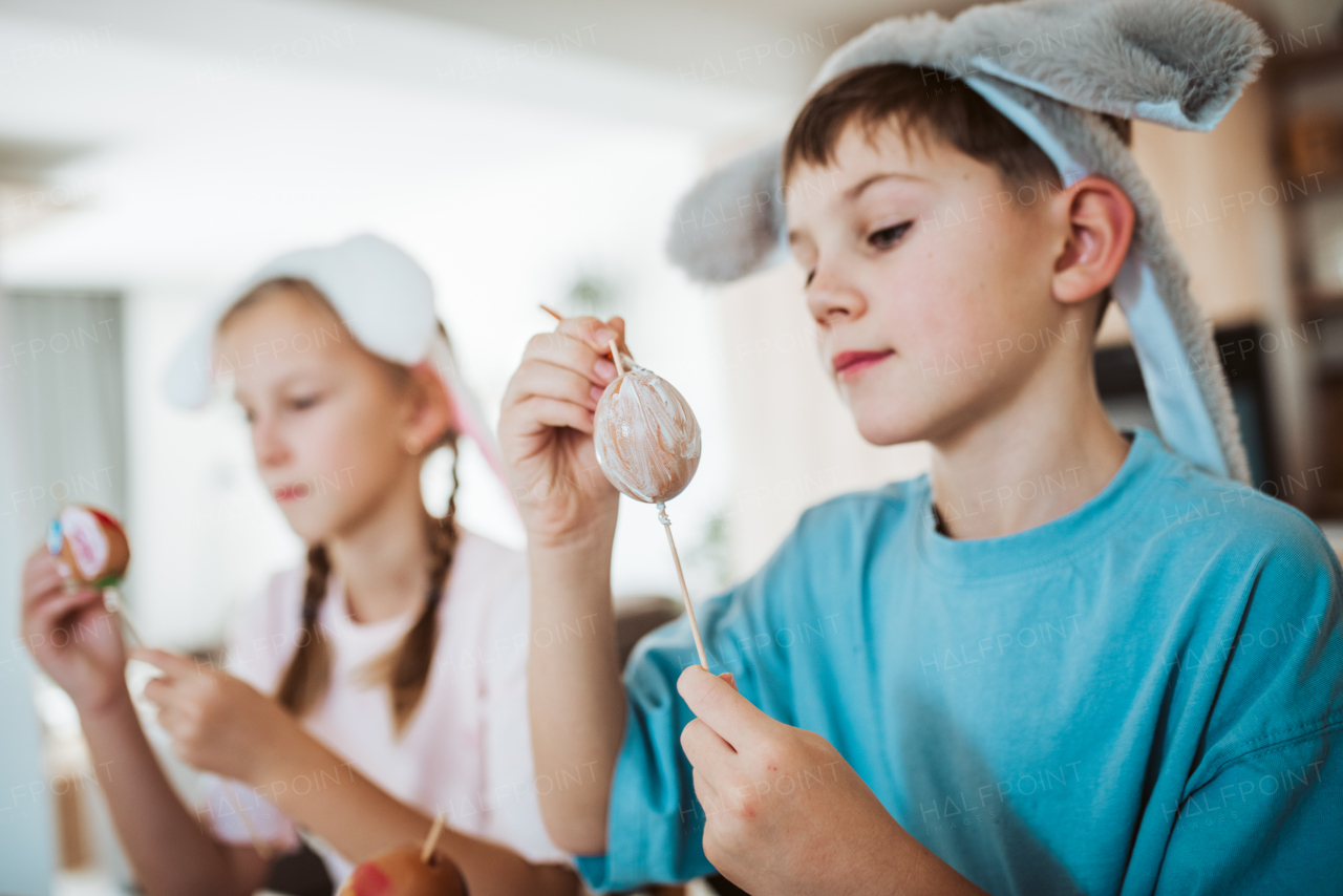 Girl and boy paiting eggs for easter. Siblings decorate egshells for easter egg decorating.